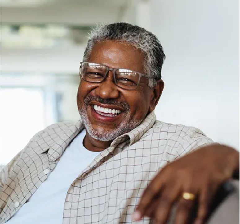 Smiling man wearing glasses and plaid shirt.