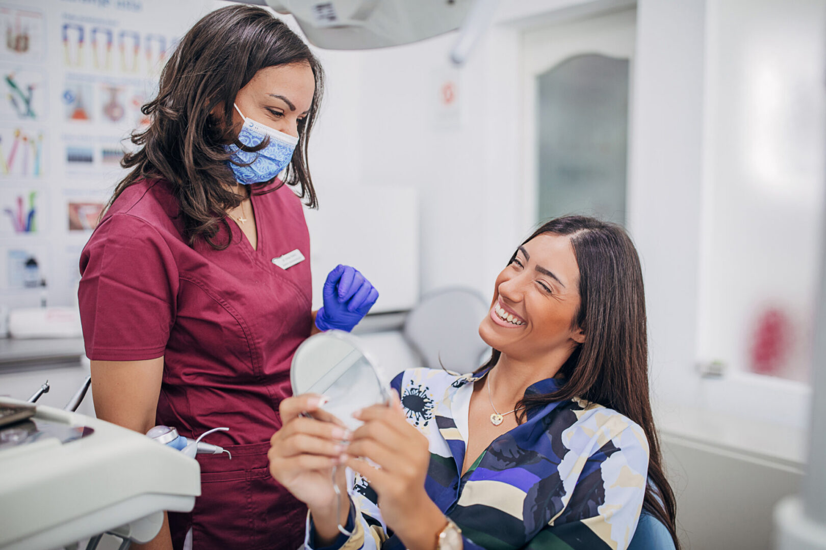 Dentist and patient smiling with mirror
