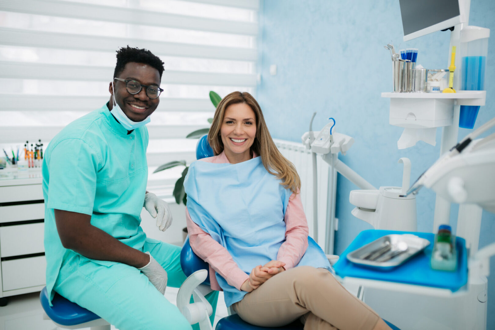 Dentist and patient smiling in clinic