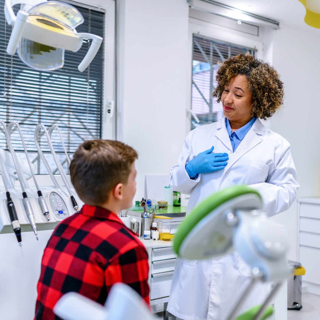 Dentist talking to a young patient.