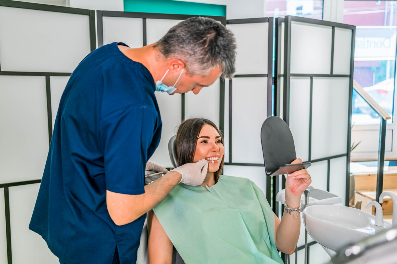 Dentist examining patient's teeth with mirror.