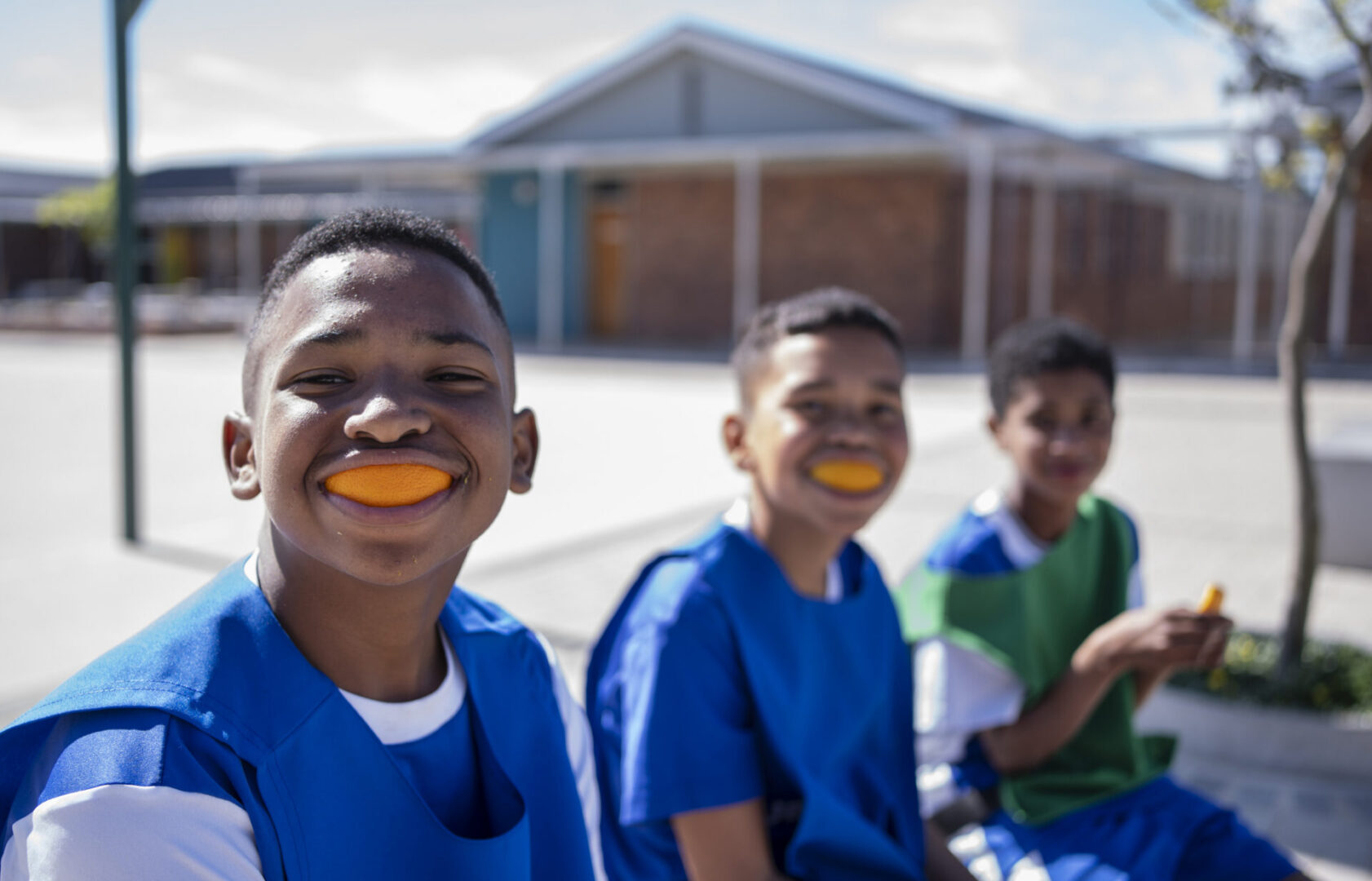 Kids enjoying oranges outside
