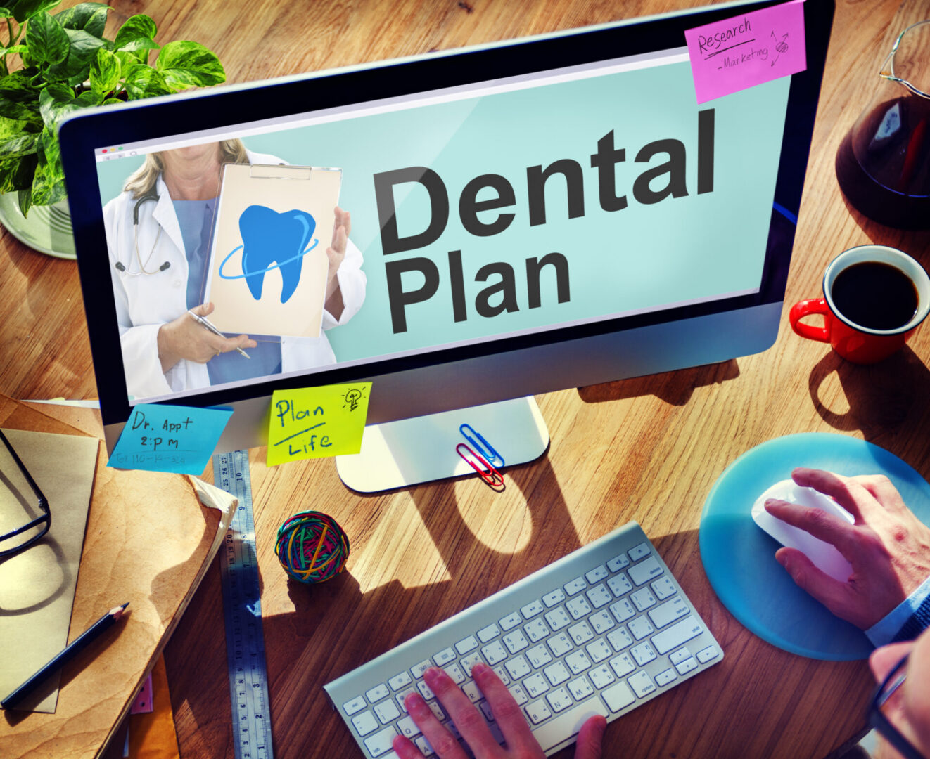 Office desk with dental plan on screen
