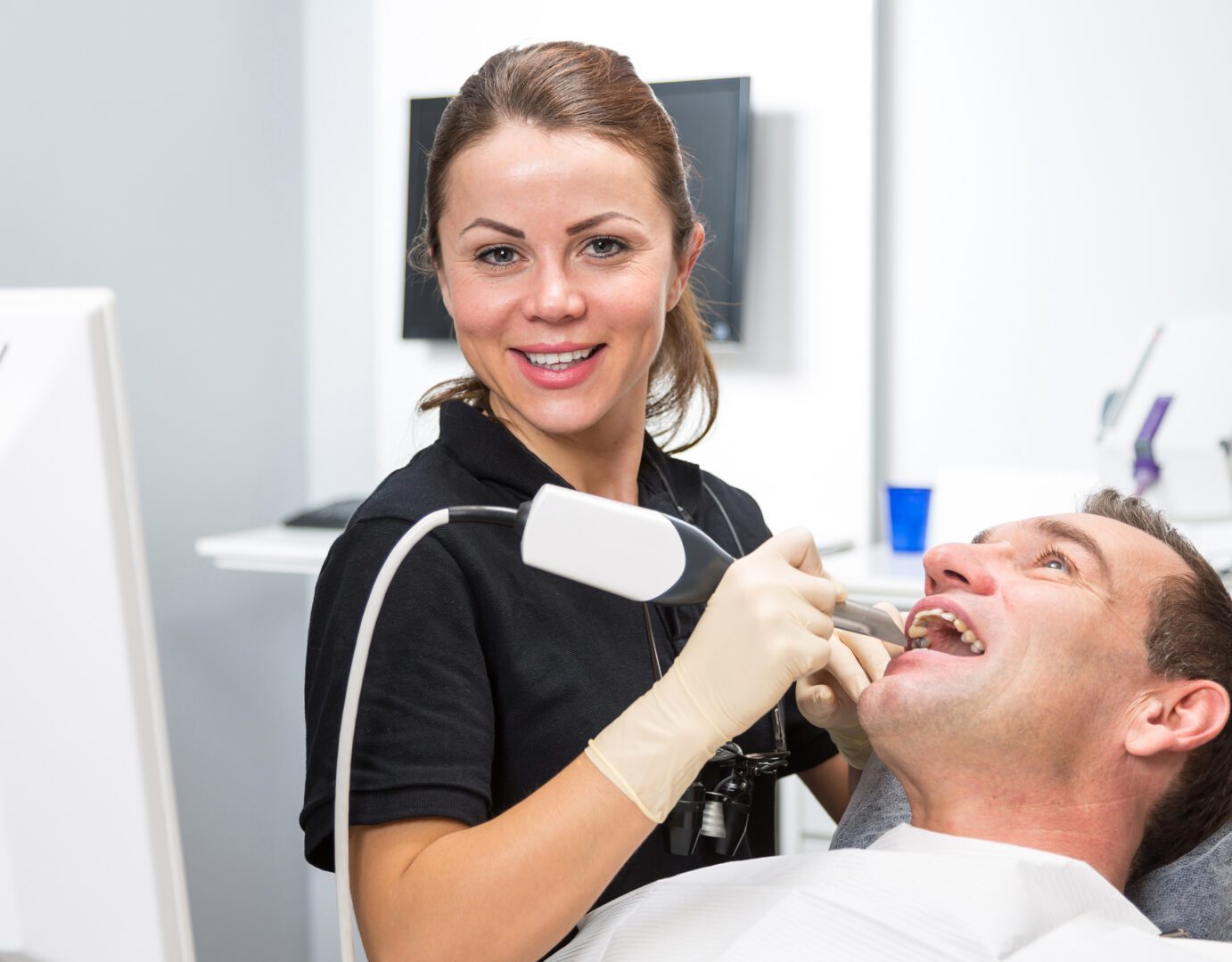 Dental professional with patient smiling