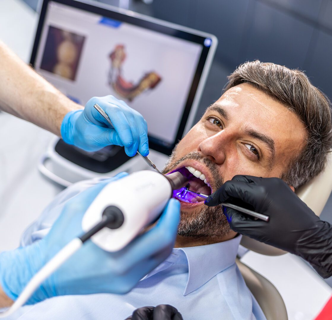Dentist using digital scanner on patient